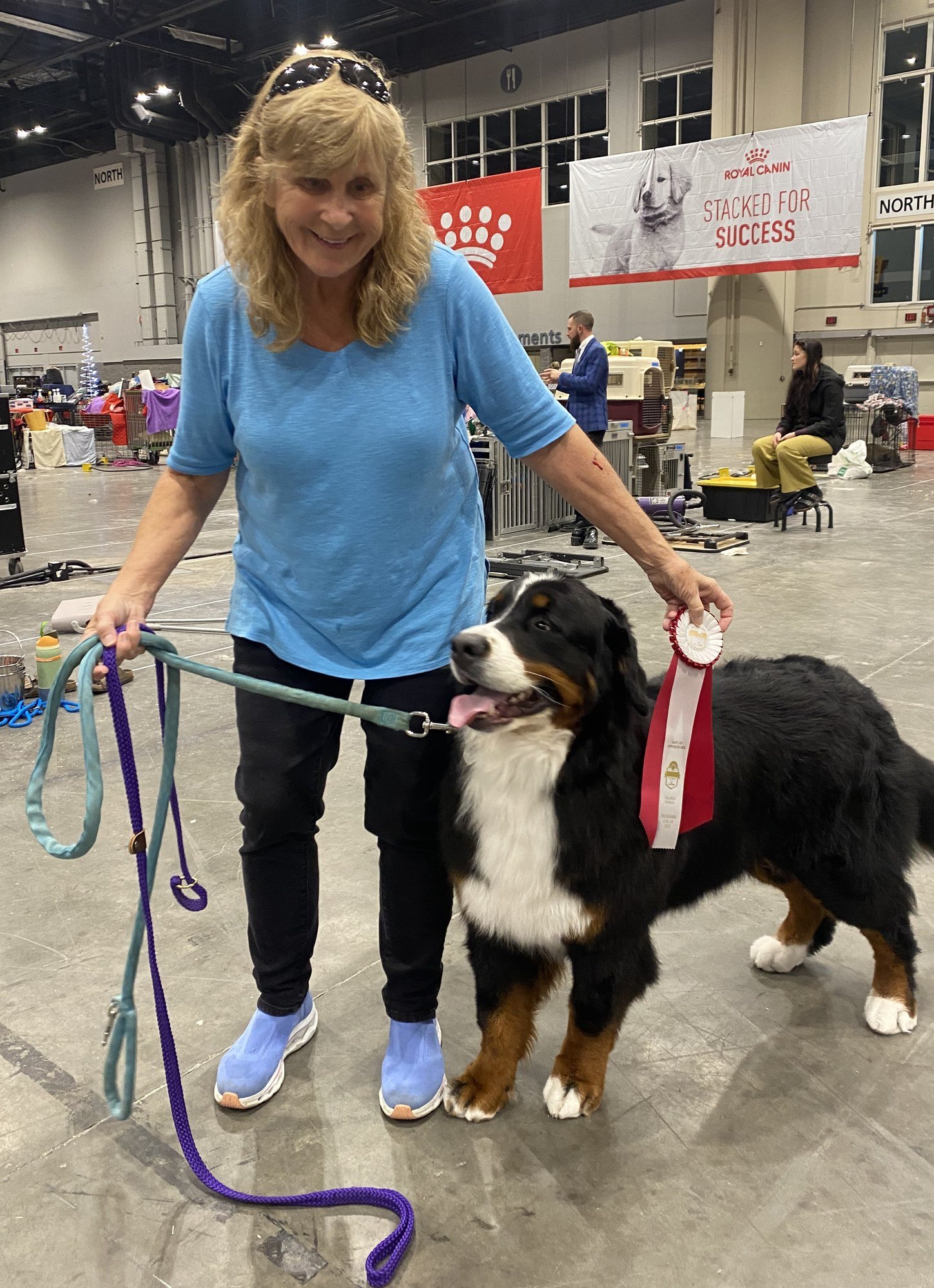 Cindy Loflin smiling broadly with her Bernese Mountain Dog at a dog show.